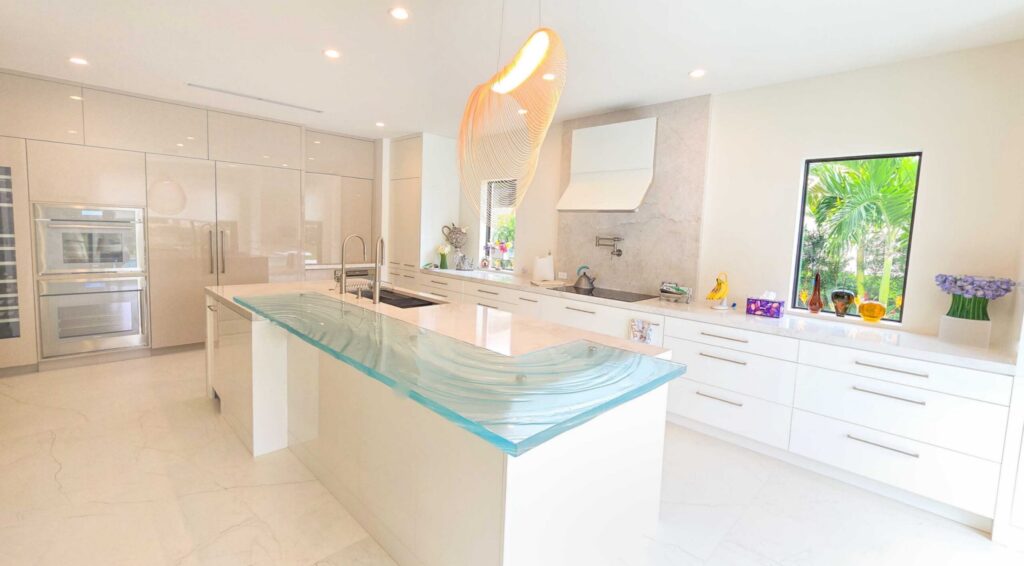 Modern L-shaped custom glass bar top designed to integrate with open concept living space in South Florida