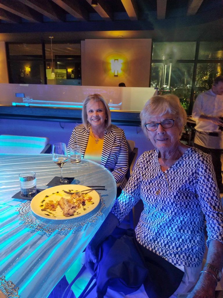 Acqua Café owner Arlene Desiderio and Barbara Downing dining at custom illuminated glass bar top in Palm Beach Florida by Downing Designs