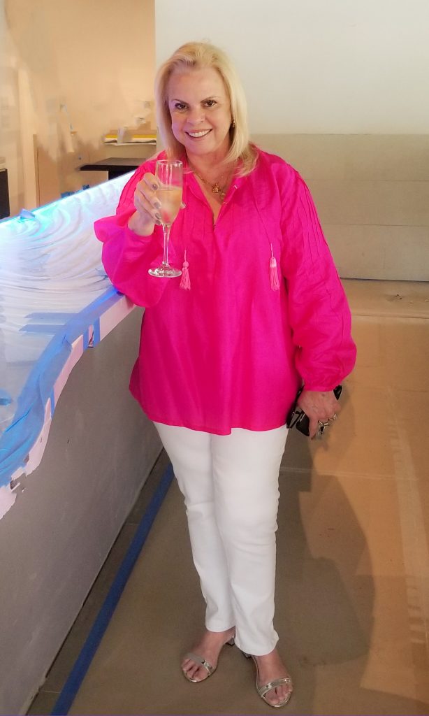 Acqua Café owner Arlene Desiderio toasting with champagne at installation of custom illuminated glass bar top by Downing Designs Palm Beach Florida