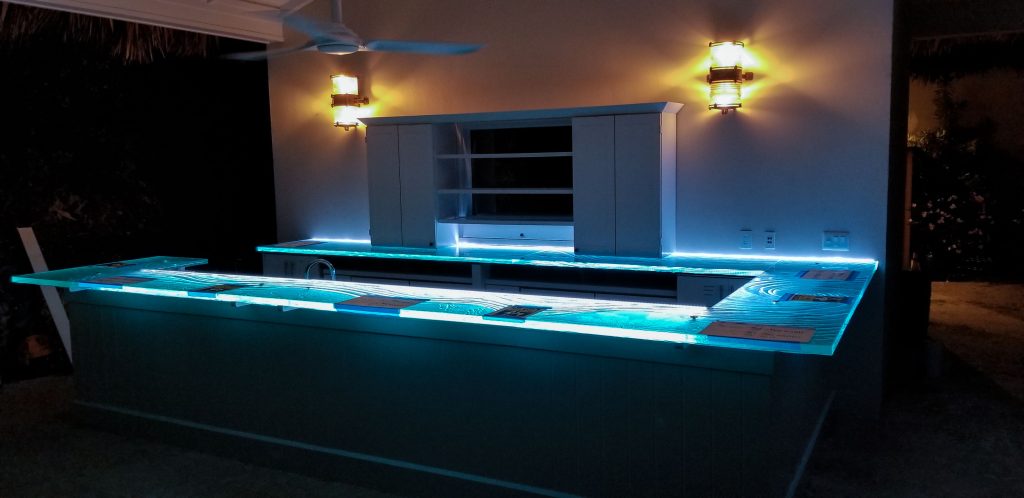 Kiln-formed glass bar top glowing at night — private island Caribbean cliffside bar by Downing Designs — synchronized LED multi-controller