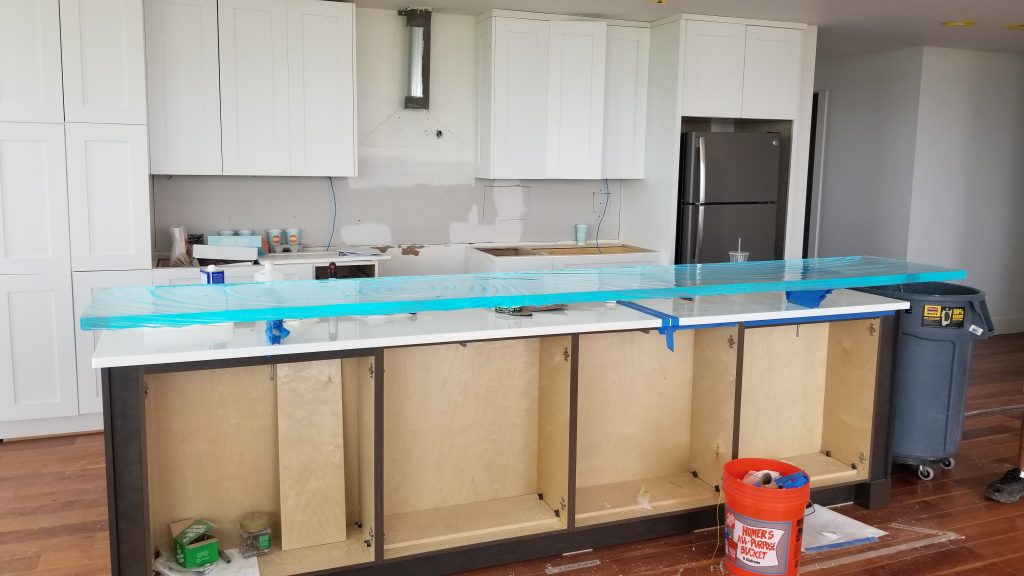 Installation day — custom kiln-formed glass high bar top by Downing Designs freshly set on white glass island countertop, Greenbridge Condominiums, Chapel Hill NC