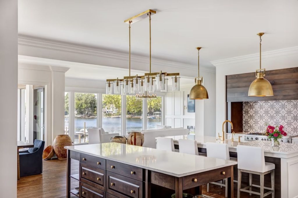 White glass kitchen island countertop by Downing Designs in a lakefront estate on Lake Norman, North Carolina — kiln-formed porcelain-enameled glass with Lake Norman visible through floor-to-ceiling windows