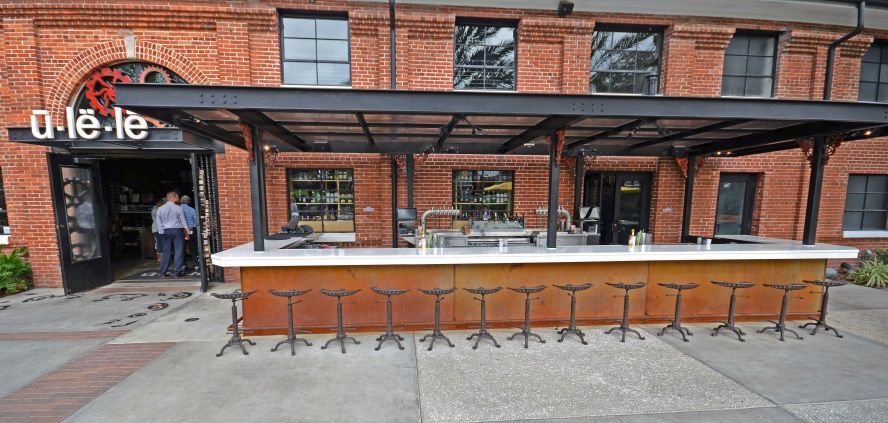 55-foot white glass outdoor bar top by Downing Designs at Ulele Restaurant, Tampa Heights — Hillsborough River waterfront, Columbia Restaurant Group, installed 2014