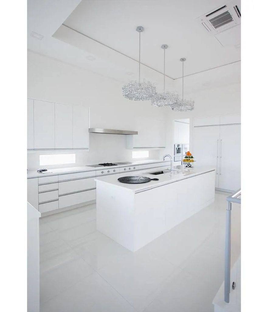 Modern all white kitchen with a white glass waterfall island Palm Coast Florida