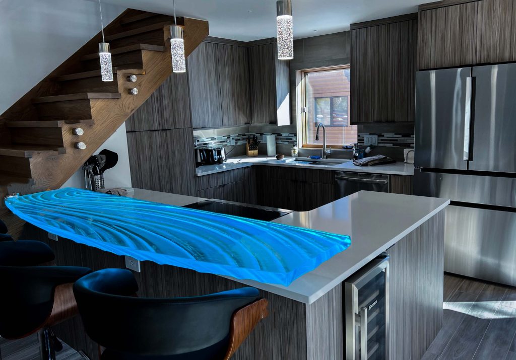 Cantilevered arced glass bar top glowing cyan blue under concealed LED, Park City Utah kitchen