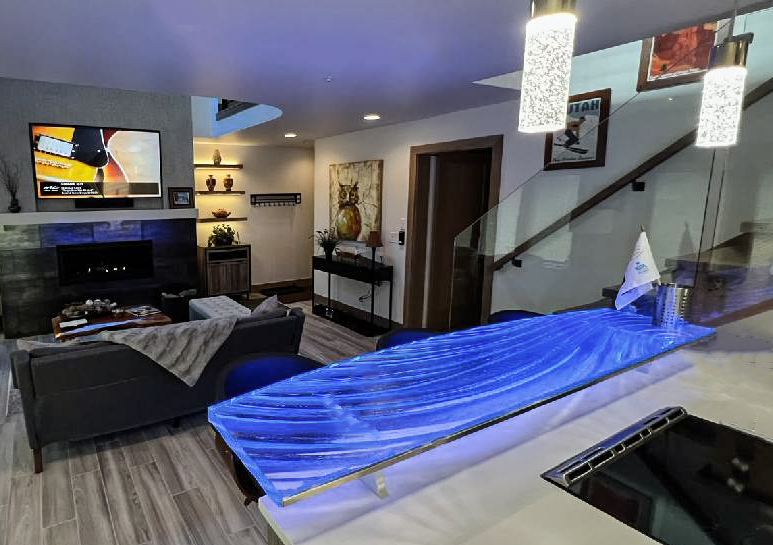Glass bar top lit deep blue in an open living space with fireplace, Park City Utah